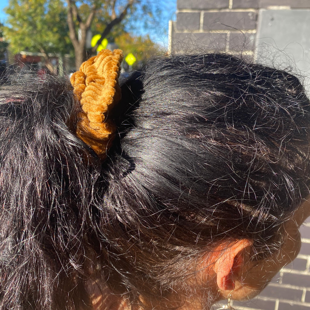 Woman wearing golden yellow Corduroy Hair Scrunchie with plastic free elastic. Made by Asiki eco store, Erskineville, Sydney, Australia.