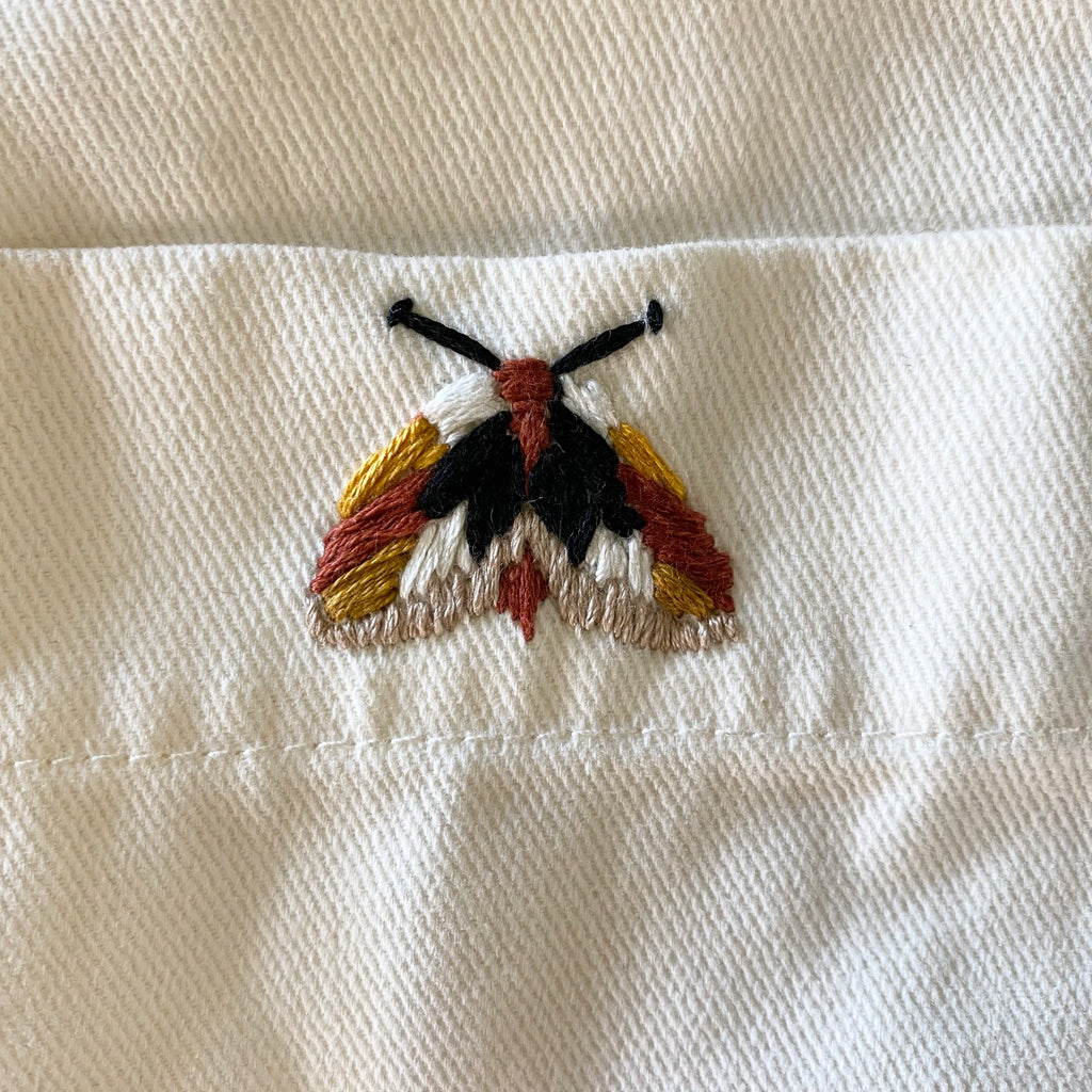 Photo of white cloth with a brown Moth motive embroidered on it, using the Visible Mending Kits from Asiki, Erskineville, Sydney, Australia. 